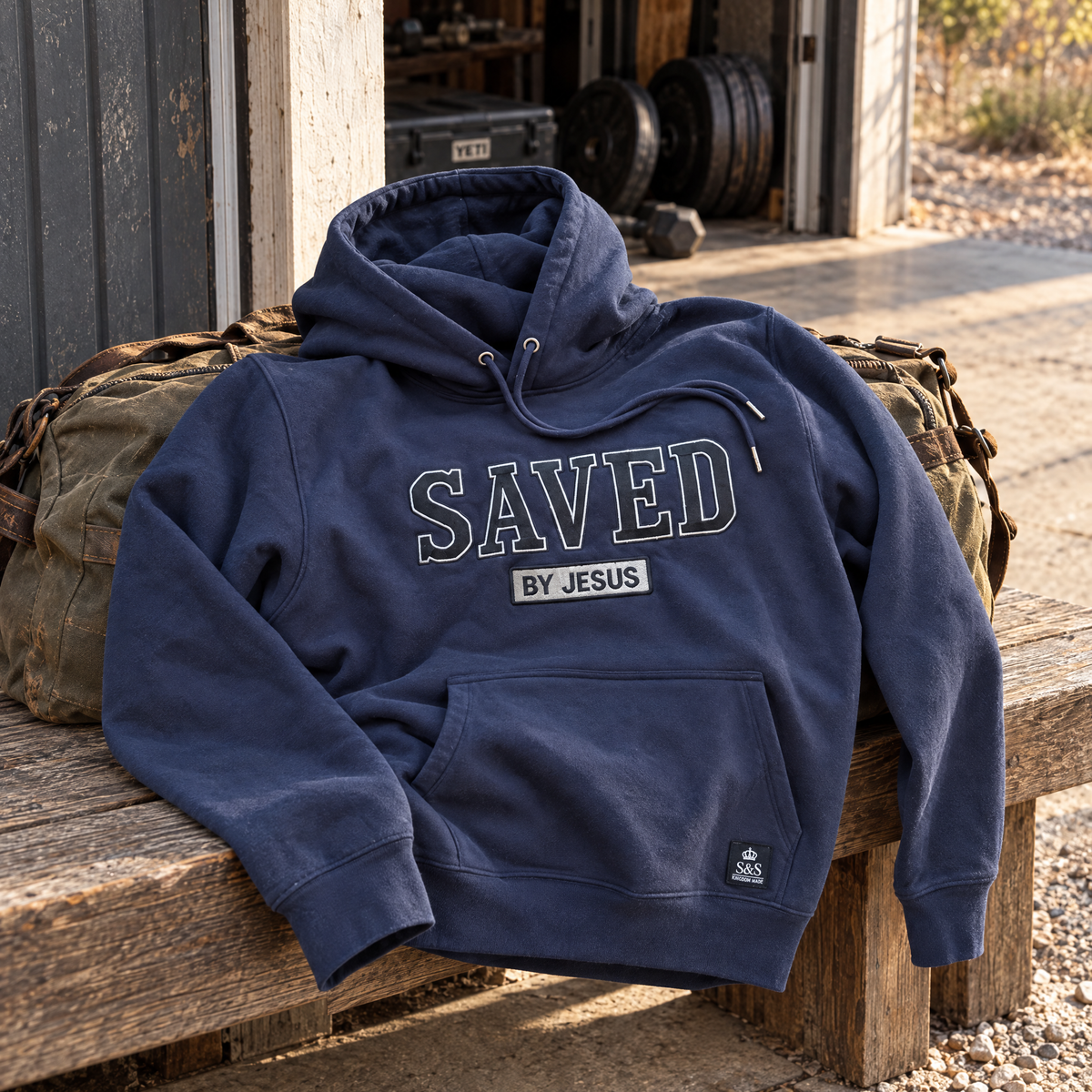 Heritage Navy Saved by Jesus hoodie front in a premium product setting with embroidered SAVED and BY JESUS details