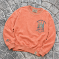 Coral-colored crewneck with 'Grace Upon Grace Surf Club' design on a stone surface