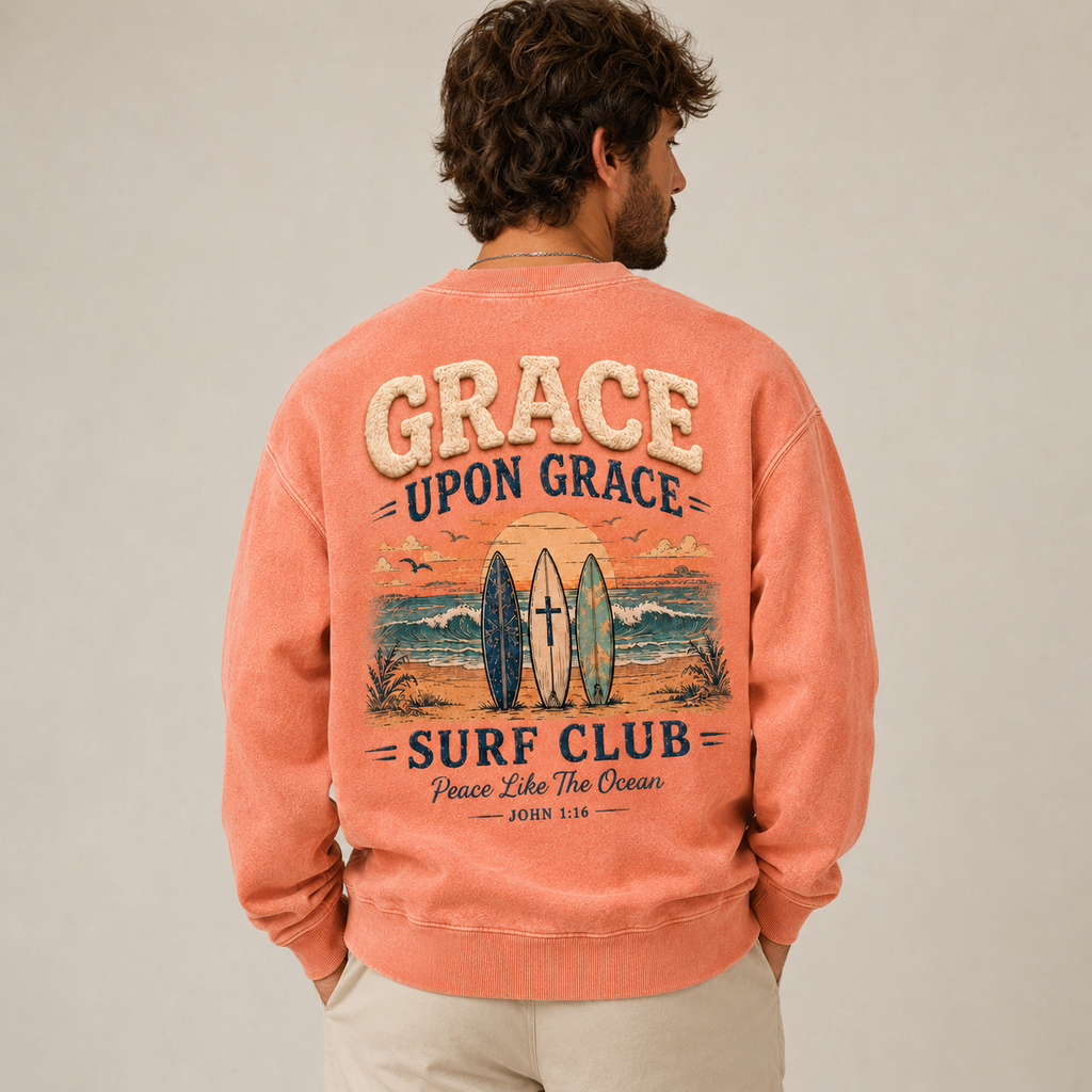 Man wearing a coral crewneck with 'Grace Upon Grace Surf Club' design on the back.