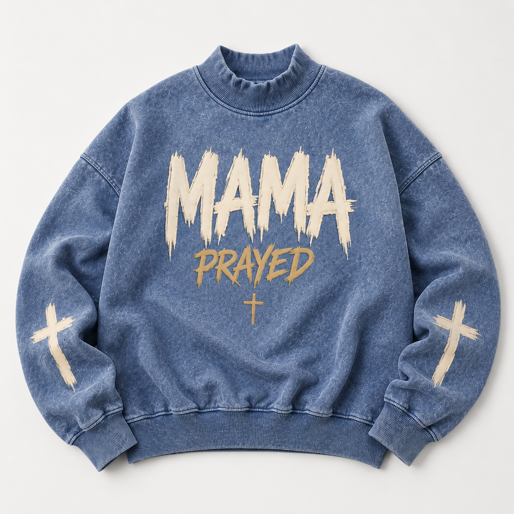 Blue sweatshirt with 'MAMA PRAYED' text and cross designs on a light gray background