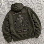 Dark Green hoodie with a cross and chain design on a stone pavement