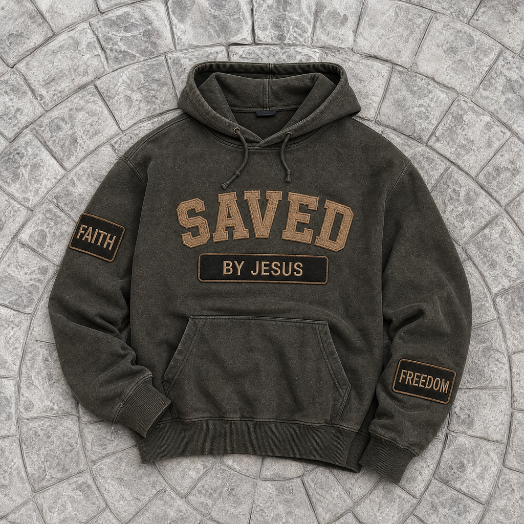Dark green/black hoodie with 'SAVED BY JESUS' text on a stone surface