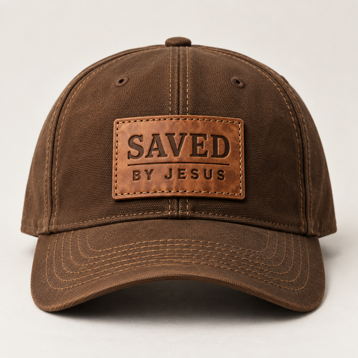 Brown cap with rectangular tan leather-look SAVED BY JESUS patch and curved brim