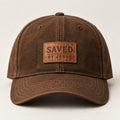 Heritage brown curved-brim cap with small tan stitched SAVED BY JESUS patch