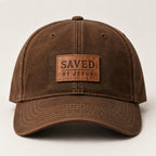 Heritage brown curved-brim cap with small tan stitched SAVED BY JESUS patch
